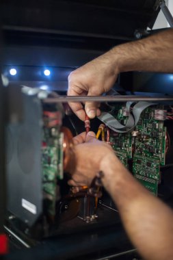 Elektrik mühendisi operatörünün yakın plan detaylı görüntüsü dijital matbaa ofisindeki büyük kaliteli endüstriyel yazıcı ve çizer makinesini tamir ediyor