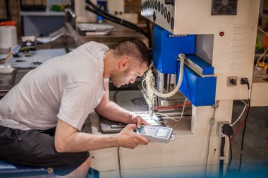 Profesyonel makinist mühendis akort ve programlama bilgisayar konsolu fabrika üretim işyerindeki yumuşak PVC dağıtım makinesinde. Endüstriyel çalışma süreci