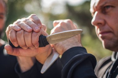 Bıçak, bıçaklı kavgaya karşı. Kapap eğitmenleri sombrada talim metodunu gösteriyor. Silah etkisiz hale getirme tekniği gösterimi
