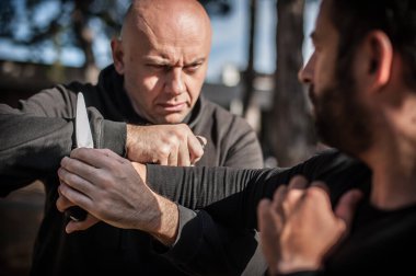 Bıçak, bıçaklı kavgaya karşı. Kapap eğitmenleri sombrada talim metodunu gösteriyor. Silah etkisiz hale getirme tekniği gösterimi