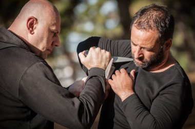 Bıçak, bıçaklı kavgaya karşı. Kapap eğitmenleri sombrada talim metodunu gösteriyor. Silah etkisiz hale getirme tekniği gösterimi