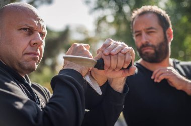 Bıçak, bıçaklı kavgaya karşı. Kapap eğitmenleri sombrada talim metodunu gösteriyor. Silah etkisiz hale getirme tekniği gösterimi