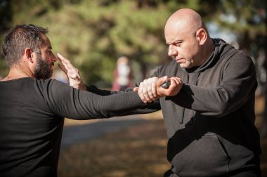 Bıçak tehdidi. Kapap eğitmeni, bıçak saldırısına karşı savunma tekniğini gösteriyor. Silah etkisiz hale getirme eğitimi. Plastik bıçakla gösteri