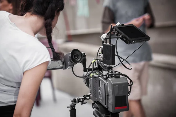 Behind the scenes. Cameraman shooting the film scene with camera on outdoor set. Photography director in movie filmmaking action