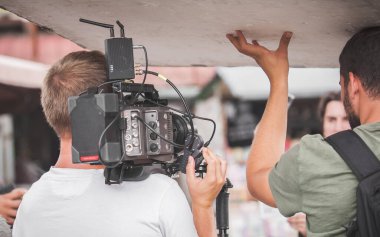 Sahne arkasında. Film ekibi açık alanda film çekimi yapıyor. Grup film yapımı üretimi