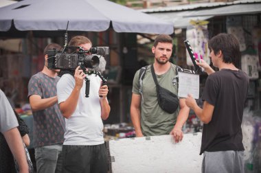 Sahne arkasında. Film ekibi açık alanda film çekimi yapıyor. Grup film yapımı üretimi
