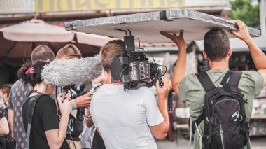 Sahne arkasında. Film ekibi açık alanda film çekimi yapıyor. Grup film yapımı üretimi