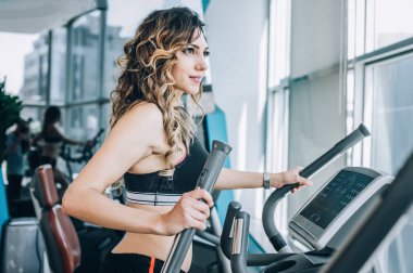 Modern spor salonunda koşu bandı üzerinde çalışan çekici kas gülümseyen fitness kadın. Güç fitness, spor, eğitim, yaşam tarzı