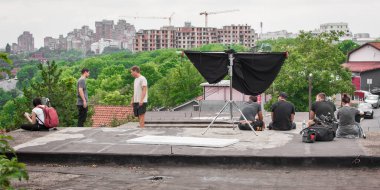 Sahne arkasında. Film ekibi ara veriyor ve çekim için dış mekânda mola veriyor. Grup film yapımı üretimi