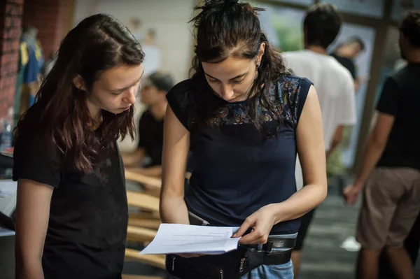 Behind the scenes. Film director and photography director checks the filming scripts on movie set. Screenwriter, cameraman, and sound technician in group filmmaking set production