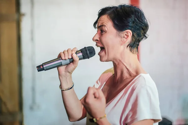 Uśmiechnięta Dowcipna Kobieta Stoi Scenie Jako Aktorka Rozmawiając Śpiewając Mikrofonu — Zdjęcie stockowe