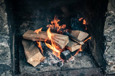 Dışarıdaki siyah taştan bir fırında yanan ateşin yakın çekimi.