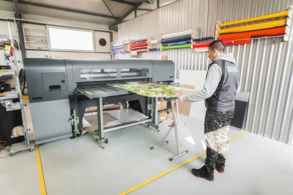 技术工人操作员在数字印刷车间的大型工业打印机和绘图机上工作 — 图库照片