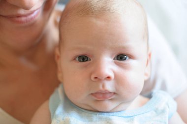 Close-up detail portrait of cute little peaceful newborn baby boy child face with beautiful open eyes. Love and family emotion