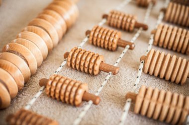 Wood massage, maderotherapy, wooden rolling pin or battledore tools for anti cellulite treatment to stimulate the lymphatic system and improve circulation concept