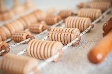 Wood massage, maderotherapy, wooden rolling pin or battledore tools for anti cellulite treatment to stimulate the lymphatic system and improve circulation concept