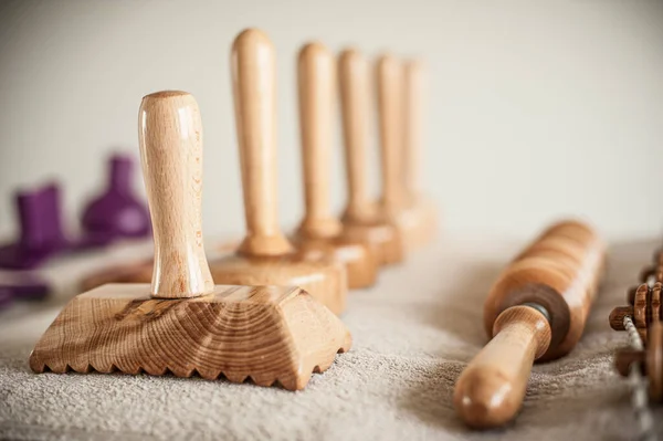 Wood massage, maderotherapy, wooden rolling pin or battledore tools for anti cellulite treatment to stimulate the lymphatic system and improve circulation concept