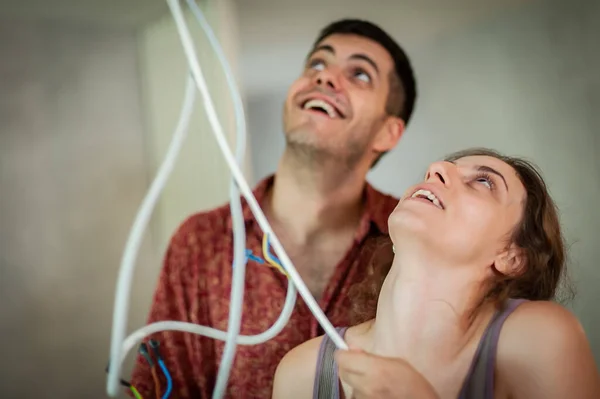 Smiling Faces Young Couple Solving Problem Cables Wires Living Together — Fotografia de Stock