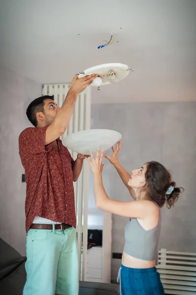 Living Together Young Man Woman Install Ceiling Light Electrical Cables — 图库照片