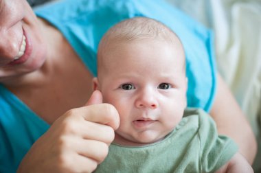 Close-up detail portrait of cute little peaceful newborn baby boy child face with beautiful open eyes. Love and family emotion