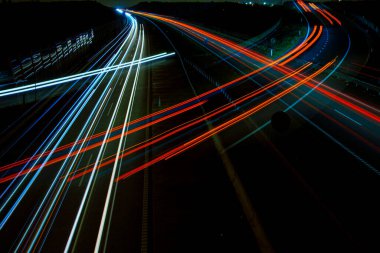 Gece lambaları. Geceleri hareket halindeki arabaların ışıkları. Uzun pozlama kırmızı, mavi, yeşil, turuncu.