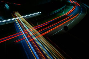 Gece lambaları. Geceleri hareket halindeki arabaların ışıkları. Uzun pozlama kırmızı, mavi, yeşil, turuncu.