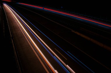 Gece lambaları. Geceleri hareket halindeki arabaların ışıkları. Uzun pozlama kırmızı, mavi, yeşil