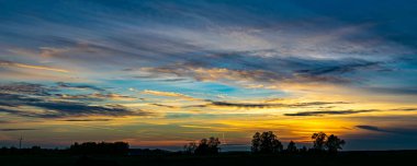 Günbatımı gökyüzü. Polonya 'da bir ormanda gün batımı