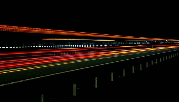 晚上开车的灯光 长期暴露于红色 — 图库照片