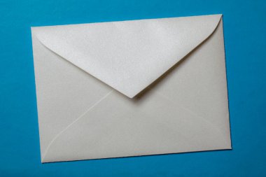 Mavi bir panoya iliştirilmiş beyaz zarf boş notu