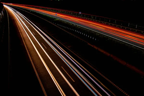 Gece lambaları. Geceleri hareket halindeki arabaların ışıkları. Uzun pozlama kırmızı, mavi, yeşil