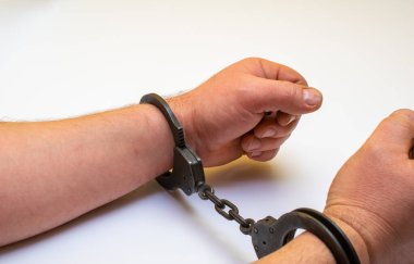 Elleri kelepçeli beyaz bir arka planda