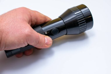 black flashlight held in the hand