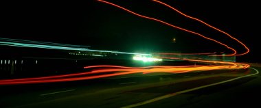 Gece lambaları. Geceleri hareket halindeki arabaların ışıkları. Uzun pozlama kırmızı, mavi, yeşil