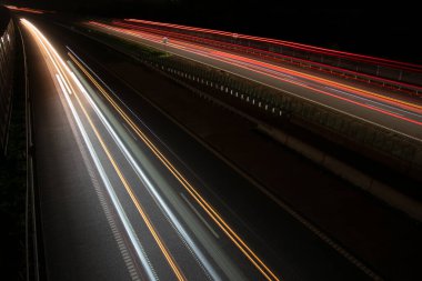 Gece lambaları. Geceleri hareket halindeki arabaların ışıkları. Uzun pozlama kırmızı, mavi, yeşil