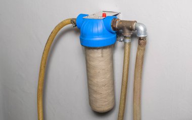 Sıradan su filtresi, duvara vidalanmış.