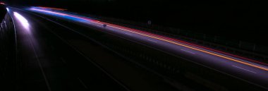 Gece lambaları. Geceleri hareket halindeki arabaların ışıkları. Uzun pozlama kırmızı, mavi, yeşil