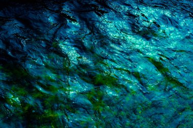 Su yüzeyindeki dalgalar koyu tonlarda