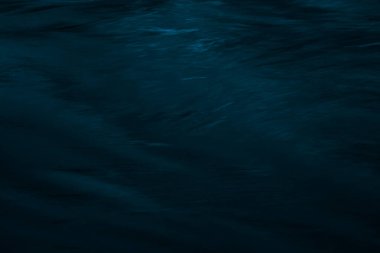 Su yüzeyindeki dalgalar koyu tonlarda