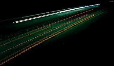 Gece lambaları. Geceleri hareket halindeki arabaların ışıkları. Uzun pozlama kırmızı, mavi, yeşil, turuncu.