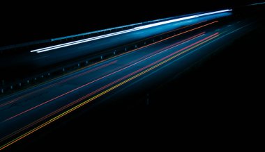 Gece lambaları. Geceleri hareket halindeki arabaların ışıkları. Uzun pozlama kırmızı, mavi, yeşil, turuncu.