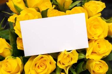 Bir buket çiçekte beyaz boş bir not.