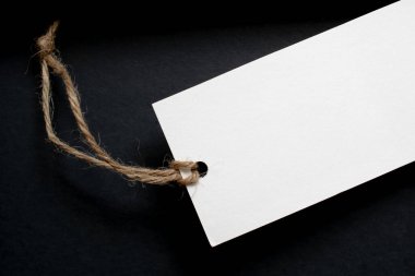 Siyah arka planda ip olan beyaz kart. metin için yer.