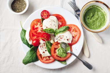Caprese salatası. Domates, mozarella peyniri, fesleğen yaprağı ve pesto sosu..