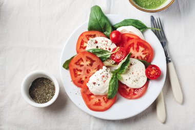 Caprese salatası. Domates, mozarella peyniri, fesleğen yaprağı ve pesto sosu..
