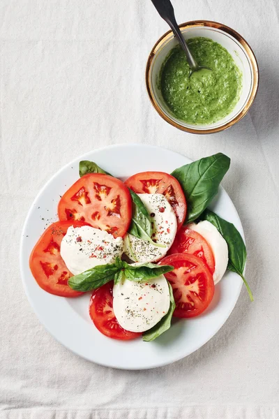 Caprese salatası. Domates, mozarella peyniri, fesleğen yaprağı ve pesto sosu..