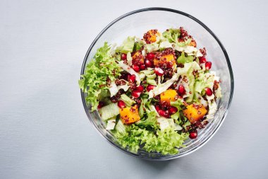 Marullu salata, balkabağı, kırmızı kinoa ve cam kasede nar..