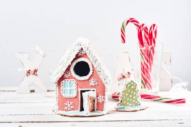 Beyaz bir Noel arka planında zencefilli kek evi.