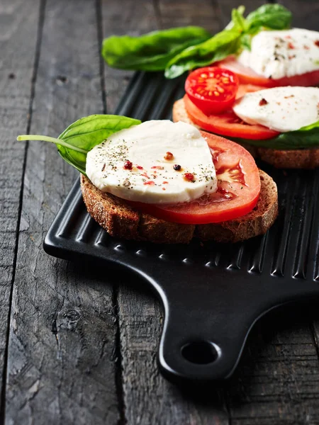 Open Sandwiches Bruschetta Mozzarella Cheese Tomatoes Basil Caprese Dark Wooden — Stock Photo, Image