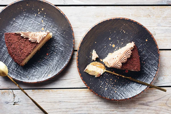 İki dilim çikolatalı kek, siyah tabakta, en üstte..